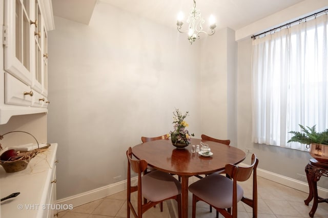 dining area featuring a chandelier, plenty of natural light, baseboards, and light tile patterned floors