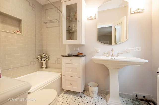 full bathroom with tile patterned floors, toilet, a tub, baseboards, and walk in shower