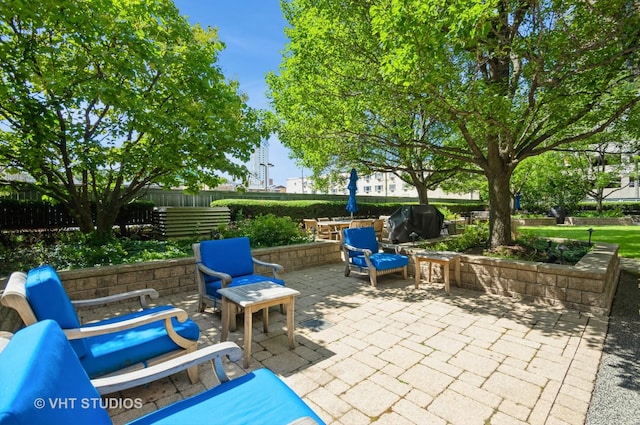 view of patio featuring a grill and fence