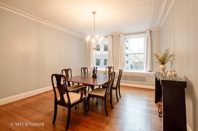 dining space with crown molding, radiator heating unit, an inviting chandelier, wood finished floors, and baseboards