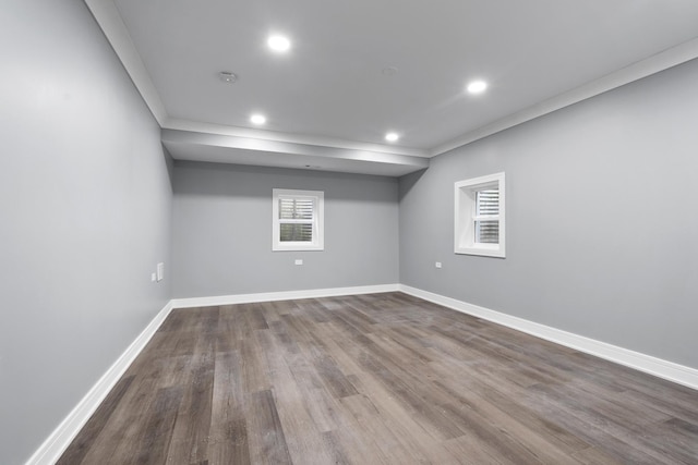 basement with ornamental molding, recessed lighting, dark wood finished floors, and baseboards