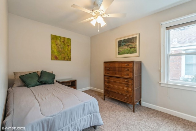 bedroom featuring light colored carpet, baseboards, and multiple windows