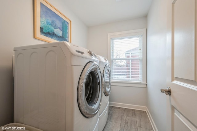 laundry room with laundry area, washing machine and clothes dryer, and baseboards