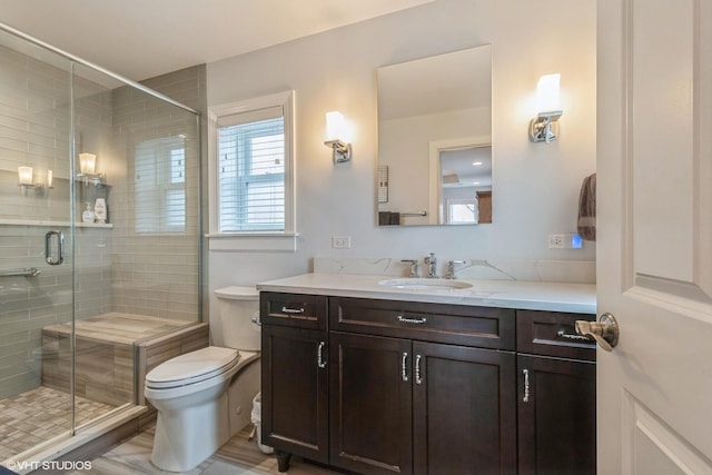 full bath featuring toilet, a shower stall, and vanity