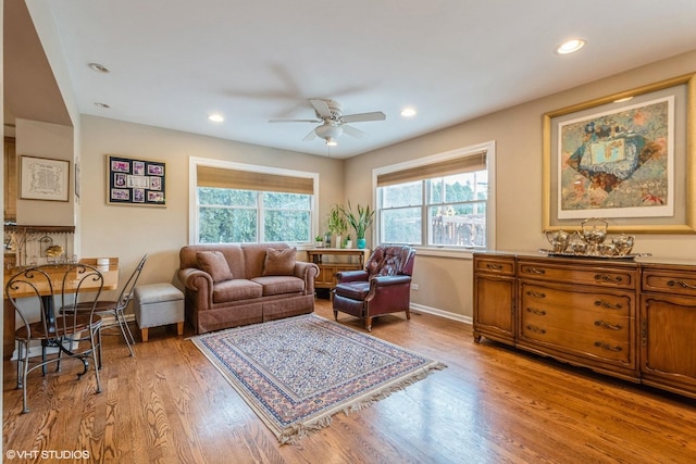 living area with light wood-type flooring, baseboards, a ceiling fan, and recessed lighting