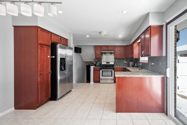 kitchen with light tile patterned floors, appliances with stainless steel finishes, a sink, and decorative backsplash