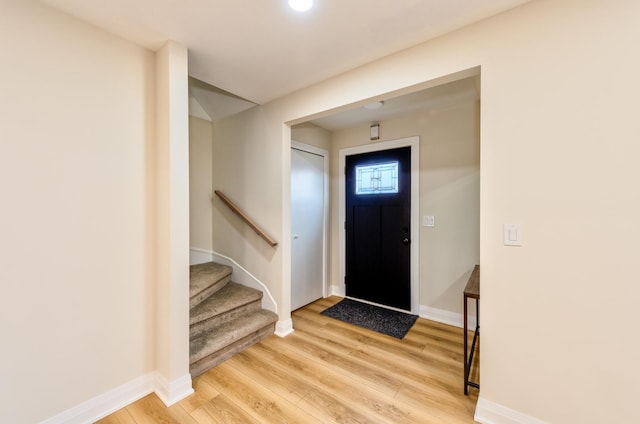 foyer with stairway, wood finished floors, and baseboards