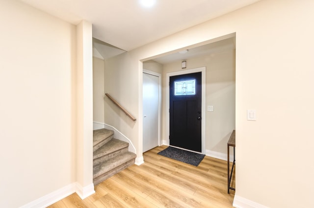 entryway featuring stairs, baseboards, and light wood-style floors