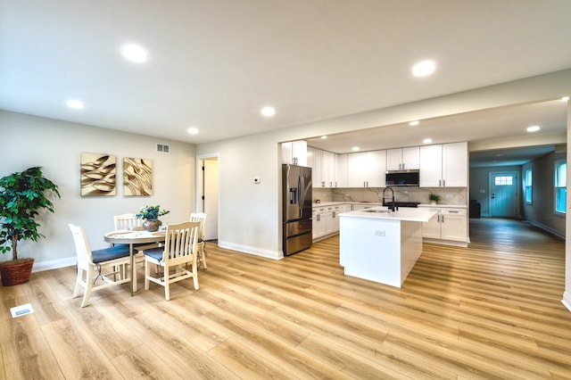 kitchen featuring visible vents, white cabinets, light wood-style flooring, appliances with stainless steel finishes, and light countertops