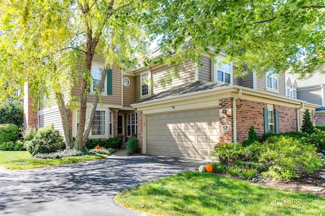 view of front of home with driveway, a garage, and brick siding