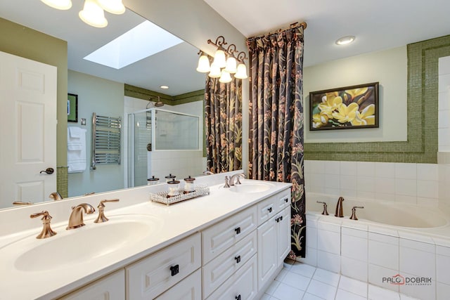 bathroom with double vanity, a skylight, a shower stall, and a sink