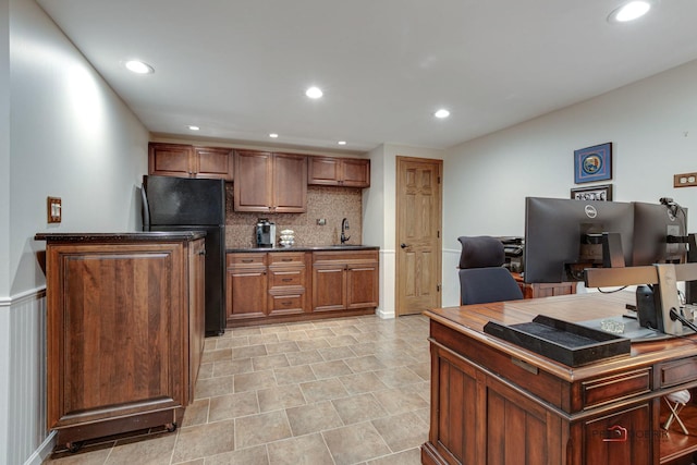 kitchen with tasteful backsplash, dark countertops, freestanding refrigerator, a sink, and recessed lighting