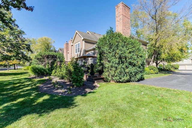 exterior space featuring a chimney and a lawn