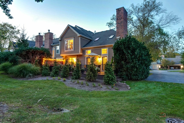 view of front of house featuring a chimney and a front lawn