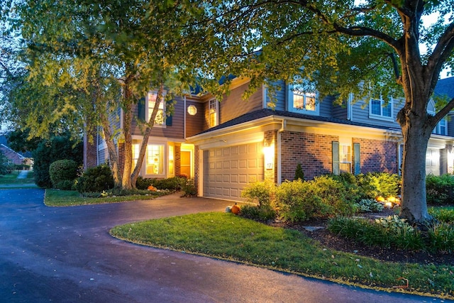 view of front of home with driveway, a garage, and brick siding