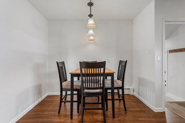 dining space featuring dark wood-type flooring and baseboards