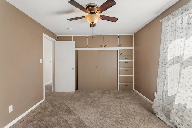 unfurnished bedroom with a ceiling fan, carpet, baseboards, and a closet