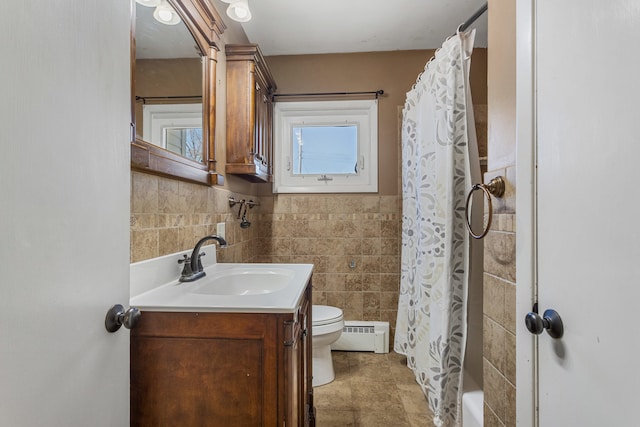 full bath featuring toilet, a baseboard radiator, vanity, and tile walls