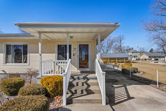 property entrance featuring a porch and concrete driveway