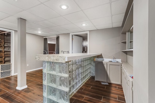 bar featuring wood tiled floor, a drop ceiling, baseboards, and recessed lighting