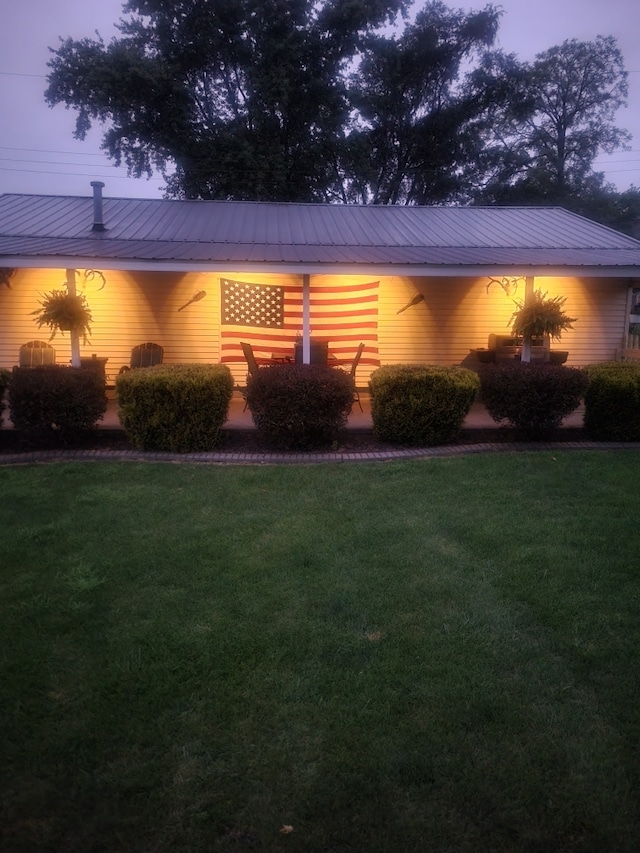 view of front of home featuring metal roof and a front yard