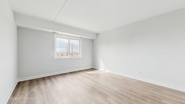 spare room with baseboards, visible vents, and light wood-style floors