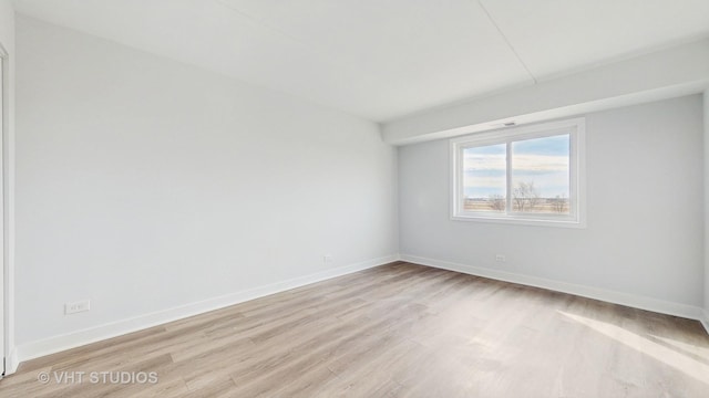 unfurnished room with light wood-type flooring and baseboards