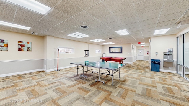 rec room featuring a paneled ceiling, visible vents, light carpet, and baseboards