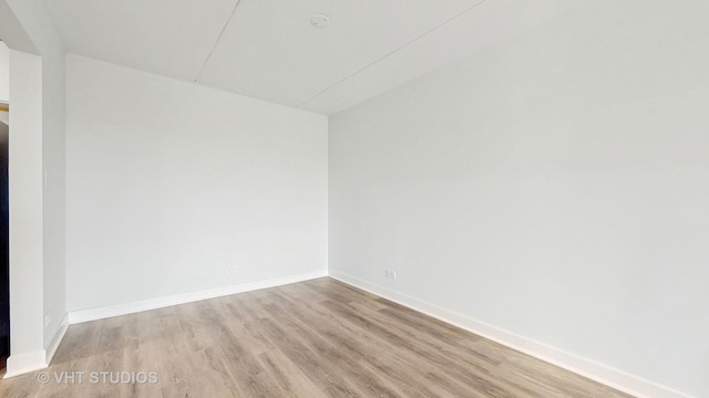 empty room featuring baseboards and wood finished floors