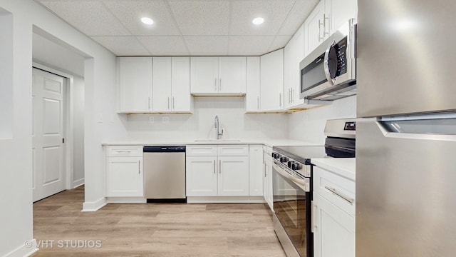 kitchen with stainless steel appliances, white cabinets, and a sink