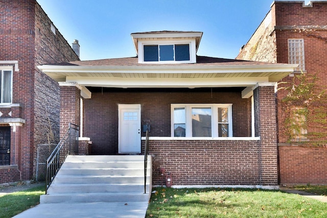 view of front facade with covered porch and brick siding