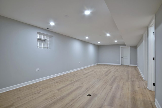 finished below grade area featuring recessed lighting, baseboards, visible vents, and light wood finished floors