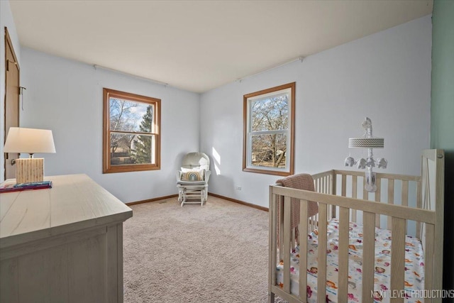 bedroom featuring baseboards, multiple windows, and light colored carpet