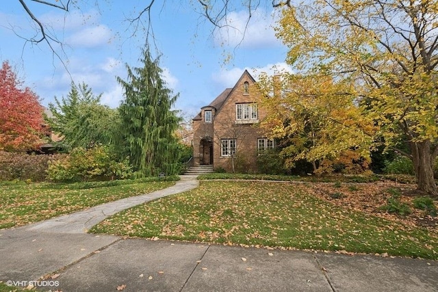 tudor home featuring a front lawn