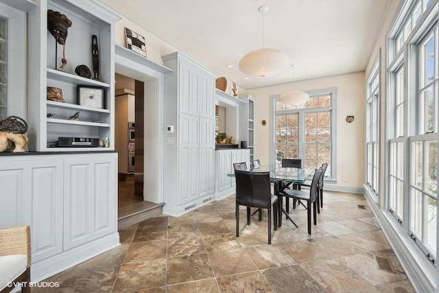 dining space with stone finish floor and baseboards