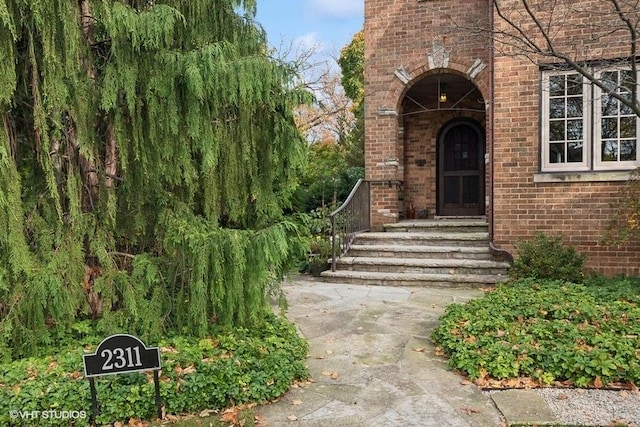 view of exterior entry featuring brick siding