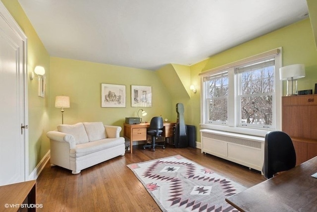 office space featuring wood finished floors and radiator