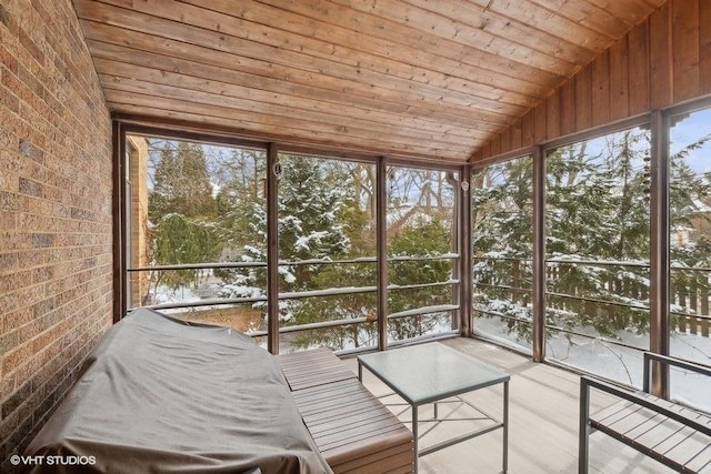 unfurnished sunroom with wood ceiling, a healthy amount of sunlight, and vaulted ceiling