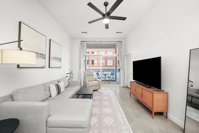 living area with visible vents, baseboards, a ceiling fan, and concrete flooring