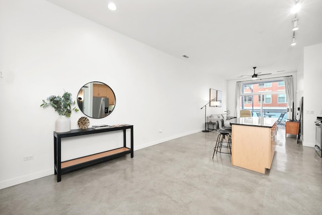 interior space with finished concrete floors, baseboards, open floor plan, and a center island