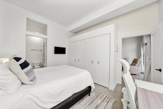 bedroom featuring finished concrete flooring and a closet