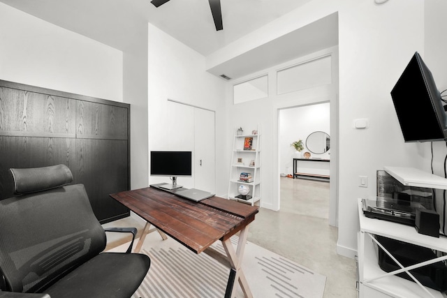 office area with concrete floors, baseboards, and ceiling fan