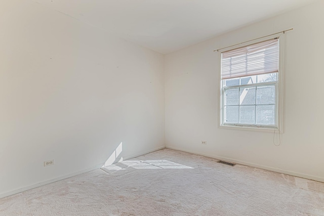 carpeted spare room with baseboards and visible vents