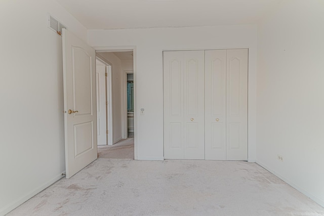 unfurnished bedroom with a closet, carpet flooring, baseboards, and visible vents