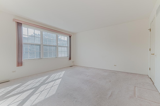 empty room with visible vents and light carpet