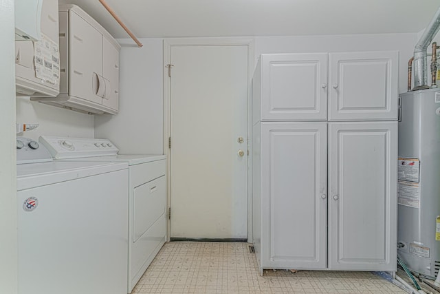 laundry room with cabinet space, light floors, water heater, and washer and clothes dryer