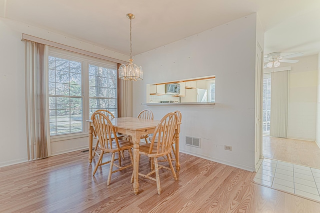 dining space featuring visible vents, baseboards, light wood-style floors, and ceiling fan with notable chandelier