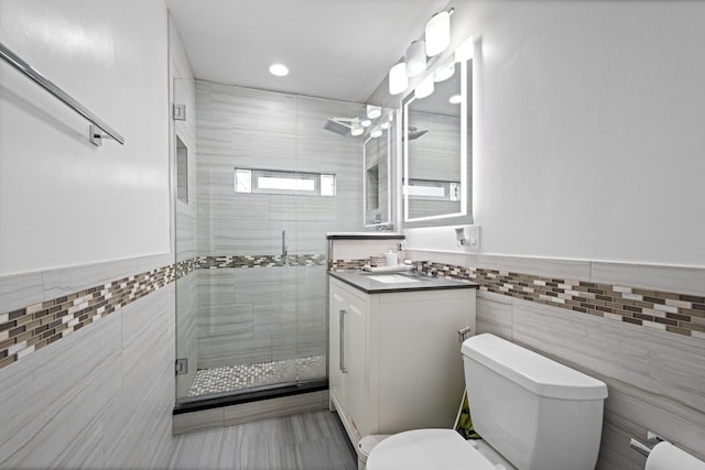 bathroom featuring a stall shower, toilet, and tile walls