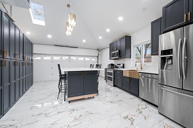 kitchen with vaulted ceiling, marble finish floor, appliances with stainless steel finishes, and a breakfast bar area