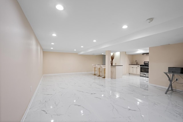 interior space featuring recessed lighting, marble finish floor, a sink, and baseboards